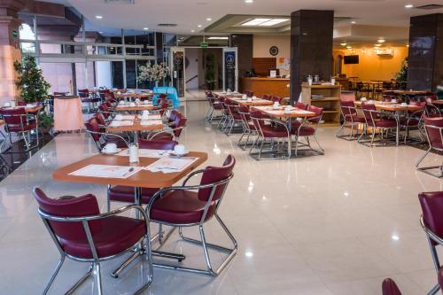 a dining hall with tables and chairs in a restaurant at Hotel Real Plaza Aguascalientes in Aguascalientes