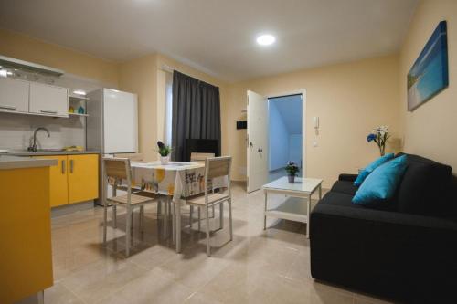 eine Küche und ein Wohnzimmer mit einem Sofa und einem Tisch in der Unterkunft La Entallada in Las Playitas