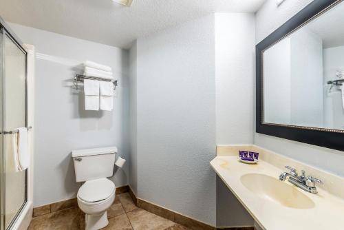 bagno con servizi igienici, lavandino e specchio di Knights Inn Searcy a Searcy