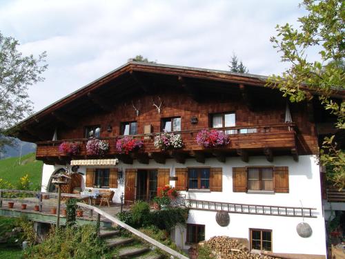 a house in the mountains with flowers at Ferienwohnung Klappacher in Maria Alm am Steinernen Meer