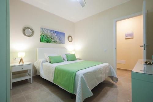 ein Schlafzimmer mit einem Bett mit einer grünen Decke in der Unterkunft La Entallada in Las Playitas