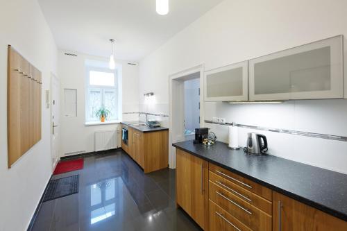 cocina con armarios de madera y encimera negra en Stadthalle - FamilyCityApartment en Viena