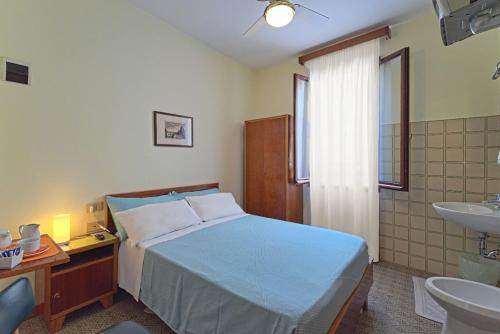 1 dormitorio con 1 cama y baño con lavamanos en Albergo Al Gobbo, en Venecia