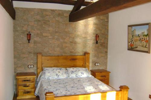 een slaapkamer met een bed en een stenen muur bij Stone Cottage SANTIAGO in Curtis