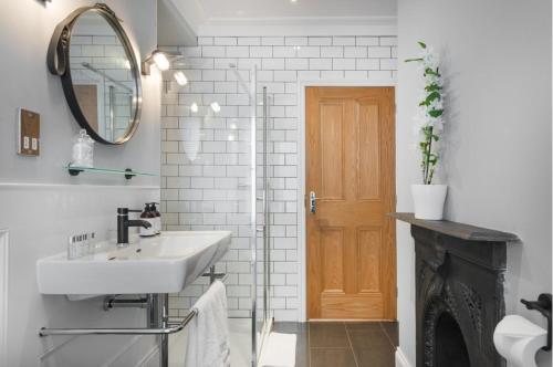 a bathroom with a sink and a mirror and a fireplace at Cliftonville Townhouse in Margate