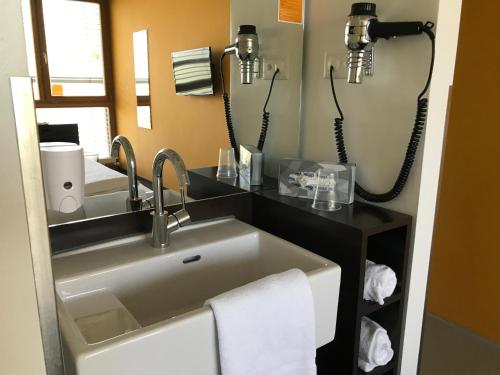 a bathroom with a sink and a mirror at CUBE SAVOGNIN inklusive Skipass in Savognin