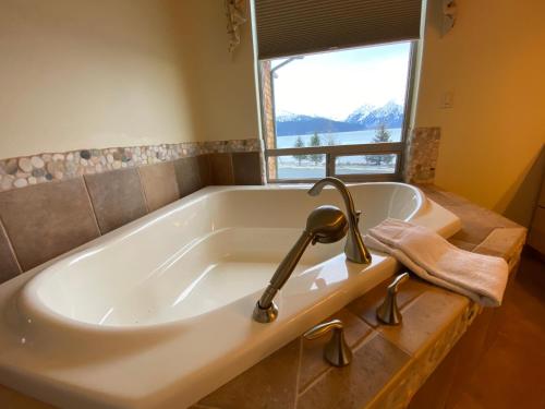 y baño con bañera y ventana. en Seward Front Row Townhouse, en Seward