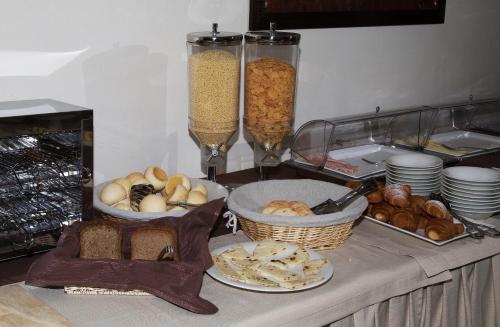 a table topped with baskets of bread and other food at Hotel Alibi in Rimini