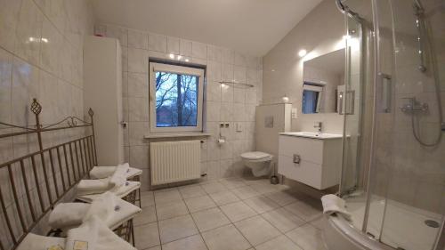 a bathroom with a shower and a toilet and a sink at Villa Genevra in Koszalin