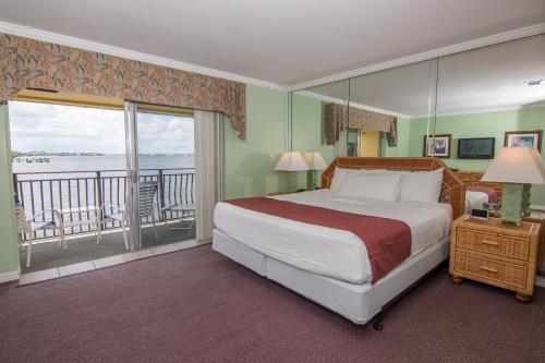 1 dormitorio con 1 cama grande y balcón en Palm Beach Resort, en Lake Worth