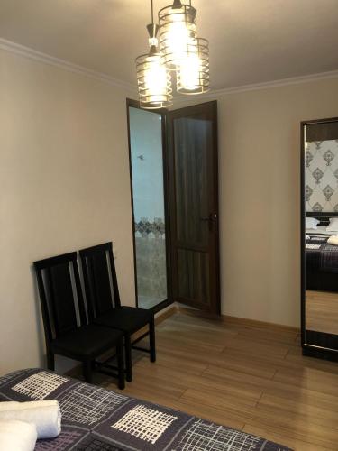 a bedroom with two chairs and a bed and a window at Wander Kazbegi Hotel in Stepantsminda