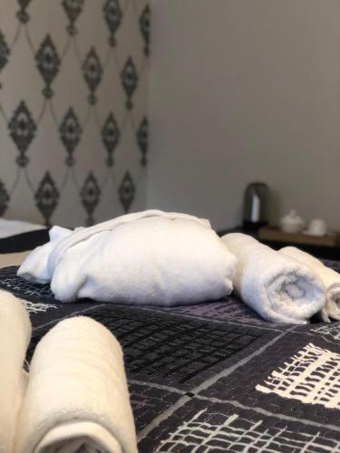 two rolls of towels laying on a bed at Wander Kazbegi Hotel in Stepantsminda