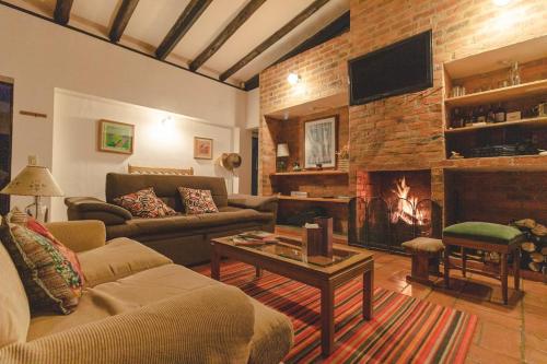a living room with a couch and a fireplace at Farallones de Sutatausa El Rincón in Sutatausa