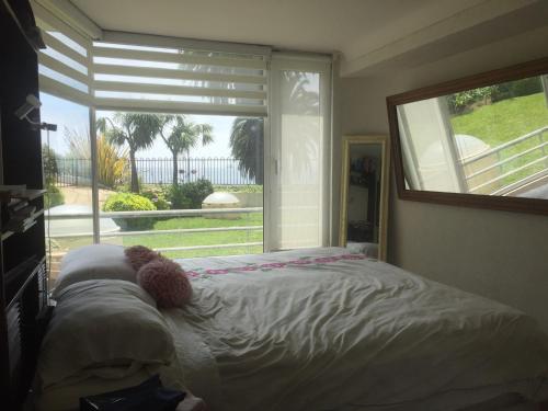 a bedroom with a bed with a teddy bear on it at Playa Miramar in Viña del Mar