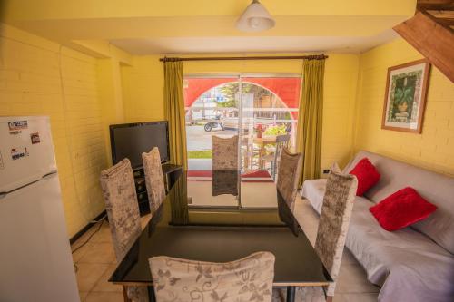a kitchen with a couch and a table and a refrigerator at Cabañas Maihue in La Serena