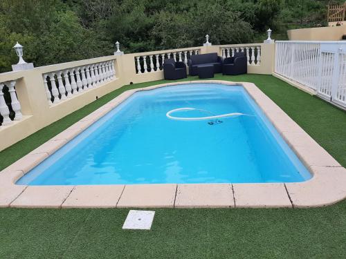 a large swimming pool on a lawn with a fence at Ribellu in Bastia