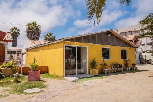 a yellow house with a black roof at Cabañas Maihue in La Serena