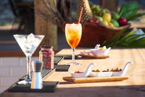 a wooden table with two glasses and a bowl of food at Kabana Hotel in Prea