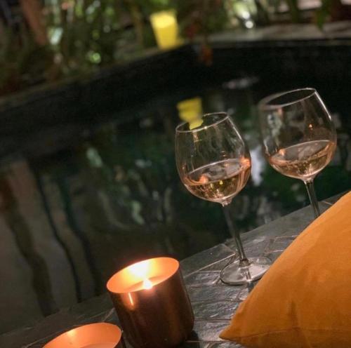 two glasses of wine and a candle on a table at Riad Dar Yasaman in Marrakesh