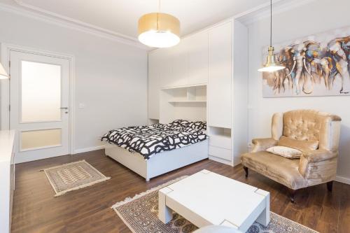 ein Schlafzimmer mit einem Bett, einem Stuhl und einem Tisch in der Unterkunft Belgrade Center Apartment Slavija Square II in Belgrad