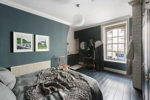 a bedroom with blue walls and a bed with a blanket at Superior Stays Rosewell House - Bath City Centre in Bath