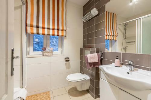 a bathroom with a sink and a toilet and a window at Varoš apartment in Split