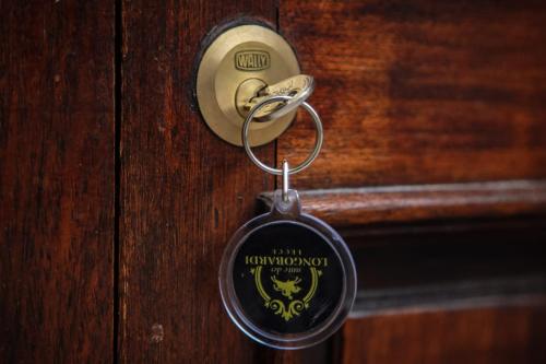 a key chain is attached to a wooden door at Suite dei Longobardi in Lecce