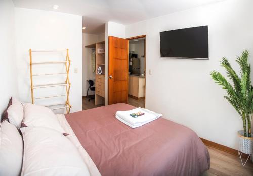 Säng eller sängar i ett rum på Resort Style Condo near heart of AQP - Gym, Pool & Netflix