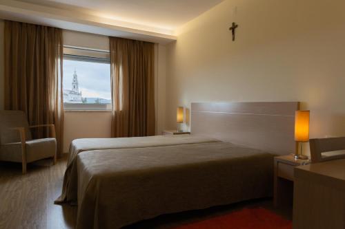 pokój hotelowy z łóżkiem i oknem w obiekcie Hotel Casa Sao Nuno w Fatimie
