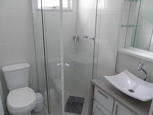 y baño con ducha, aseo y lavamanos. en 1016 - Locação de Temporada em Bombinhas - Residencial Alameda Verde Apto 103, en Bombinhas