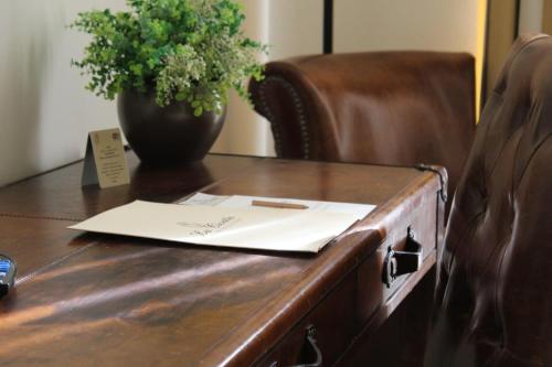 a desk with a paper and a vase on it at La Civetta in Foggia