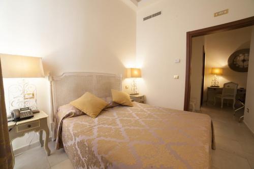 a bedroom with a bed with two lamps and a table at La Civetta in Foggia