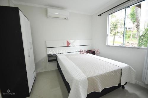 1 dormitorio con 1 cama en una habitación con ventana en 1016 - Locação de Temporada em Bombinhas - Residencial Alameda Verde Apto 103, en Bombinhas