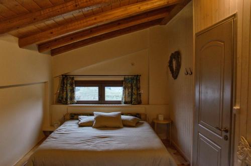 sypialnia z dużym łóżkiem i oknem w obiekcie Levandes Houses w Kalawricie
