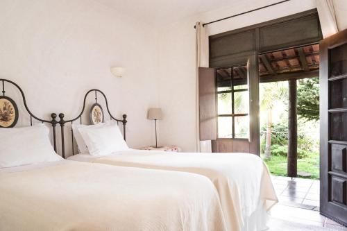 two beds in a bedroom with a window at Casas de Campo do Pomar B&B - Self Check-in in Santana