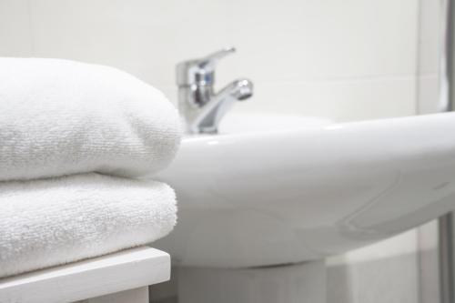 een stapel handdoeken op een wastafel bij Casas de Campo do Pomar B&B - Self Check-in in Santana