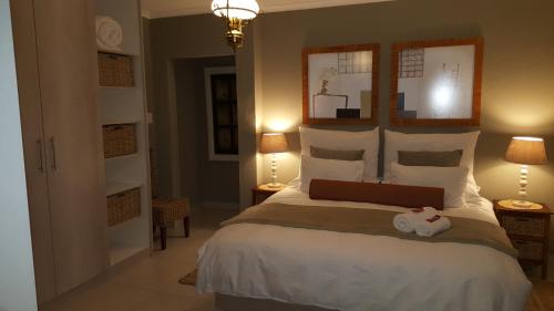 a bedroom with a large bed and two lamps at Guest House Frame Ace in Bellville