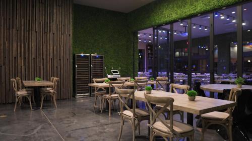 a restaurant with tables and chairs and green walls at Magic Village Views Trademark Collection by Wyndham in Orlando