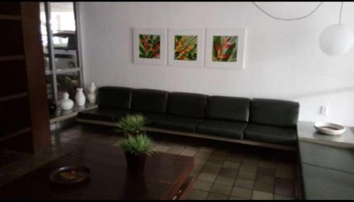 a living room with a green couch and a table at AMPLA e CONFORTÁVEL SUITE - PERTO DO CENTRO DE CONVENÇÕES-FEIRAS-CONVENÇÕES-RECIFE in Recife