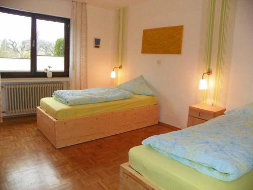 a bedroom with two beds and a window at Reiter- und Ferienhof Redder in Bad Driburg