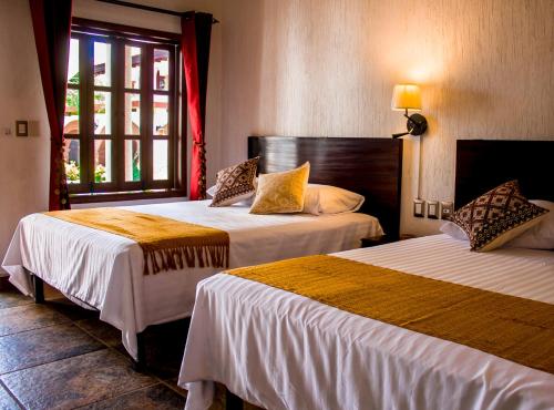 um quarto de hotel com duas camas e uma janela em Hotel Casa del Agua em Tuxtla Gutiérrez