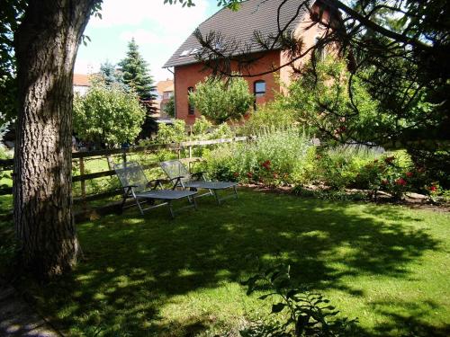 a picnic table and two chairs in a yard at Ferienwohnung Markert in Blankenburg