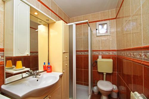 a bathroom with a sink and a toilet and a mirror at Apartments Barbaresko in Lumbarda