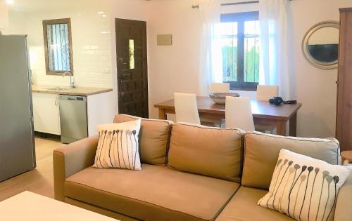 een woonkamer met een bank en een keuken bij Casa con Jardín en Denia in Denia