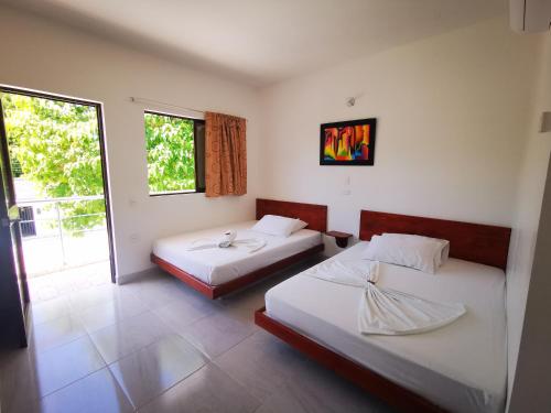 Habitación con 2 camas y ventana en Hotel Paraiso Plaza, en Puerto Triunfo
