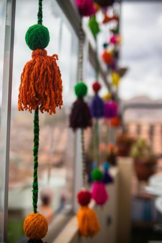 a bunch of colorful yarn hanging from a window at Home Garden Hotel in Cusco