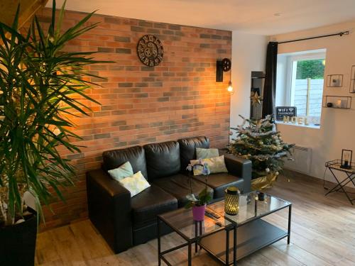 a living room with a couch and a brick wall at Gite 5 pers avec 2h espace bien-être privatisé inclus dans le prix de la nuit 80m2 de détente in Équilly