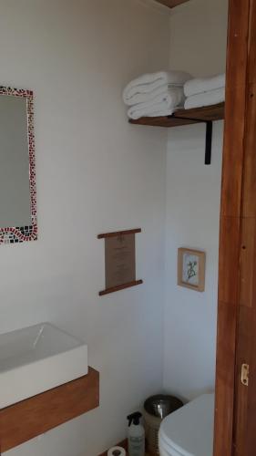 een badkamer met een toilet en handdoeken aan de muur bij Cerro Electrico - Off The Grid Tiny Houses in El Chalten