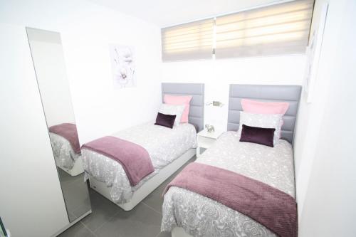 1 dormitorio con 2 camas y ventana en Fantastic apartment with sea views en Playa del Inglés