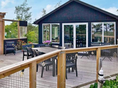 a deck with tables and chairs on a house at 4 person holiday home in KERSBERGA in Åkersberga
